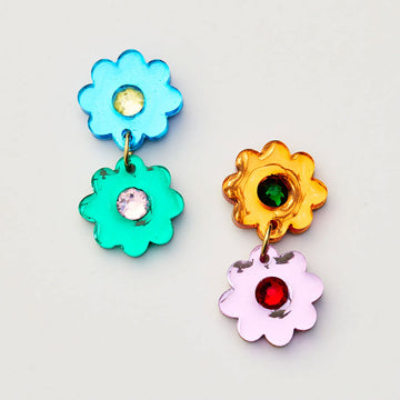 Colorful flower-shaped earrings with gemstones on a light gray background