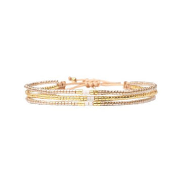Set of gold beaded bracelets on a white background.