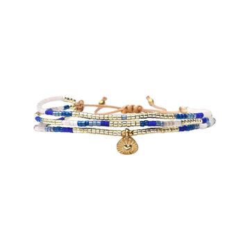 Multistrand bracelet with blue, white, and gold beads on a white background.