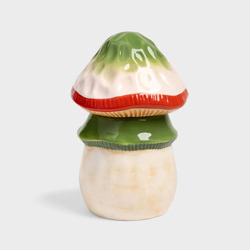 Mushroom-shaped container with a red and green cap a light gray background.