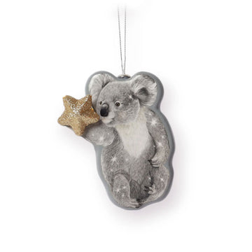 A koala shaped Christmas ornament holding a gold star.