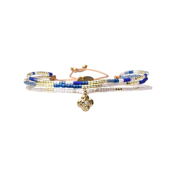 Set of beaded bracelets with a gold charm on a white background.