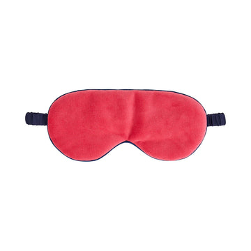 Front view of a velvet eye mask in pink with a dark blue satin strap.