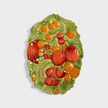 Decorative ceramic plate with fruit design on a light gray background.