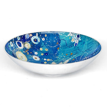 A large stainless steel salad bowl printed with artwork by Stephen Jupurrula Nelson on the inside in blue and yellow.