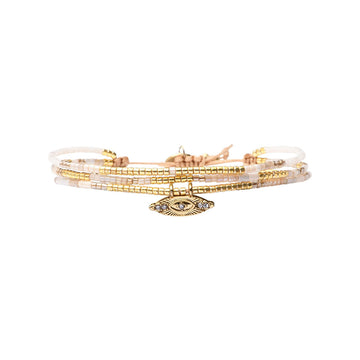 A beaded bracelet with three strands in gold and beige.