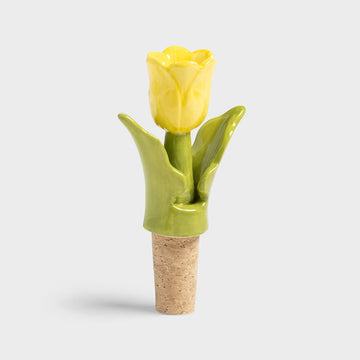 Ceramic yellow tulip-shaped bottle stopper on a white background.