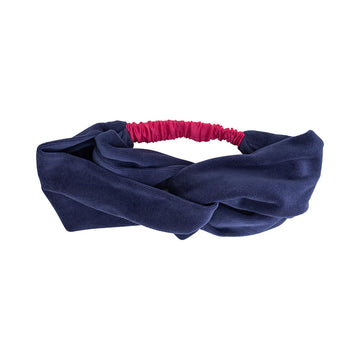 A velvet headband in dark blue with a twist design.