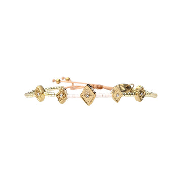 A white beaded bracelet with diamond shaped gold charms.