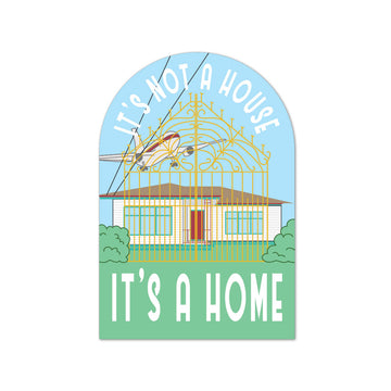 Decorative magnet with airplane and house illustration, text 'It's not a house, it's a home'.