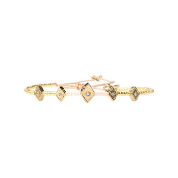 Gold bracelet with diamond-like stones on a white background.