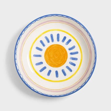 Side view of a blue ceramic bowl with decorative rim on a light gray background.