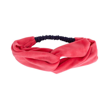 A velvet headband in pink with a twist design.