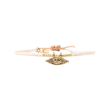 Bracelet with gold evil eye charm on a white background.