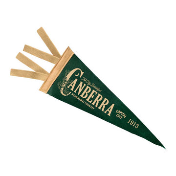 A green triangular Canberra sports pennant with cream lettering, shown with four felt tags extending from the top on a plain white background.