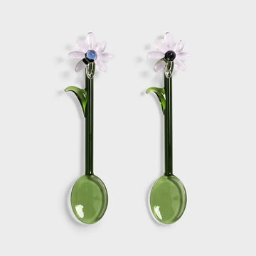 Glass spoons in green decorated with clear flowers on the tops.
