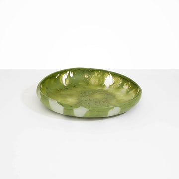 A large round shallow bowl in an olive green resin.