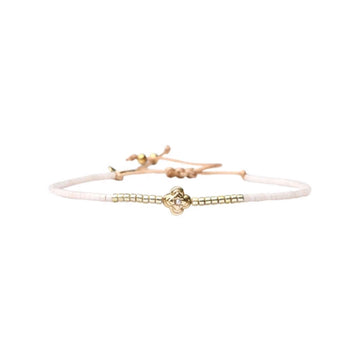 Bracelet with gold and white elements on a white background.