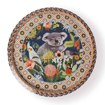 A round tin tray illustrated with a koala in the middle surrounded by flowers and birds with geometric borders.