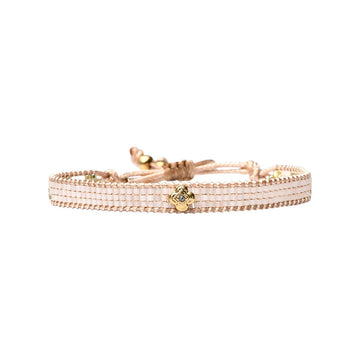 A thick beaded bracelet with a gold flower charm.