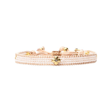 A thick beaded bracelet with a gold flower charm.
