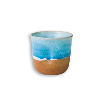 Ceramic mug with blue top and brown bottom on a white background.