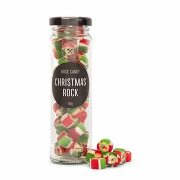A tall skinny glass container filled with rock candy and the label 'Christmas Rock'.