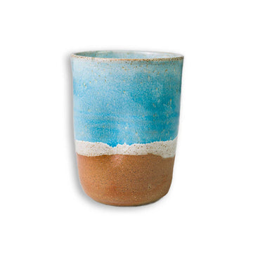 Ceramic cup with blue and brown gradient on a white background.