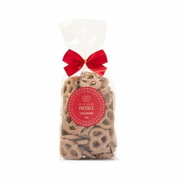 A clear bag filled with caramel covered pretzels and tied with a red bow.