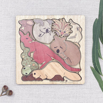 A wooden puzzle featuring pieces shaped like Australian animals arranged in a square board.