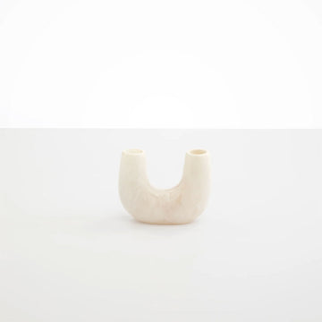 A small vase in a U shape made from cream resin.