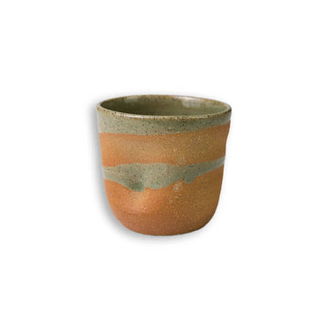 Ceramic cup with two-tone brown and green design on a white background.