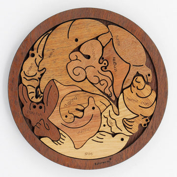 A wooden puzzle featuring pieces shaped like marine animals arranged in a round base.