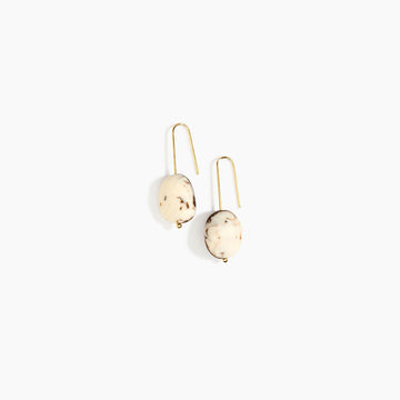 Pair of earrings with beige resin stones on a white background.