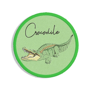 A round embroidered patch with a picture of a crocodile and the heading 'Crocodile'.
