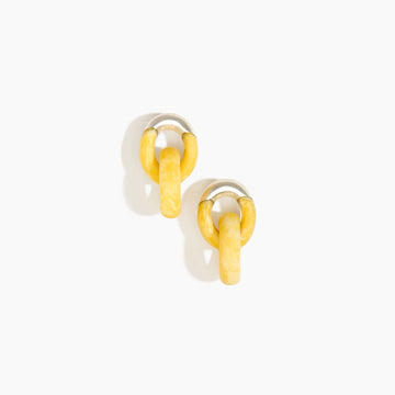 A pair of earrings made up of two hoops intertwined made from yellow resin.