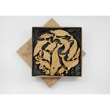 A wooden trivet with marine animal shape joined together inside a square box.