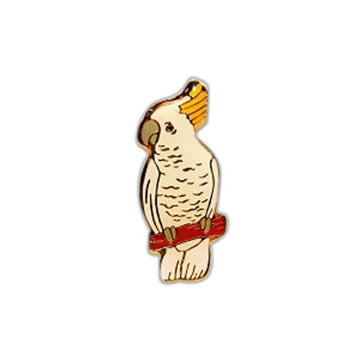 An enamel pin shaped like a cockatoo.
