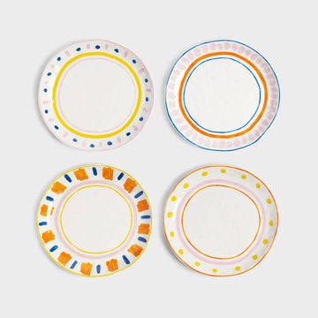 Four round ceramic plates pictured each featuring a different coloured stripe and spot border.