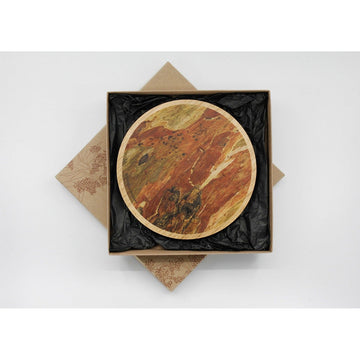 A wooden round trivet illustrated with a gum bark pattern inside a square box.
