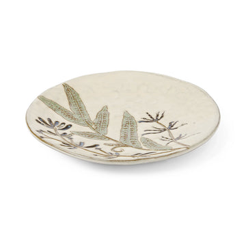 Ceramic plate with leaf design on a white background.
