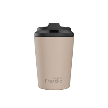 A ceramic reusable mug in an oat brown colour with a black lid.