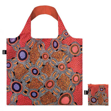 A red tote bag printed with artwork by Jennifer Napaljarri Lewis next to a matching pouch.