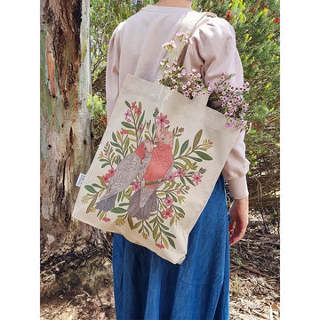 Tote bag with pink cockatoos and floral design on a beige background.