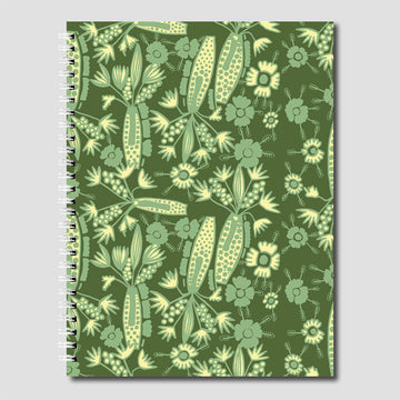 A spiral bound journal printed with flowers and plants in green and yellow on a green background.
