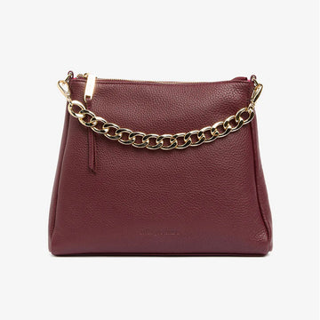 A burgundy leather bag with a short chunky gold chain strap.