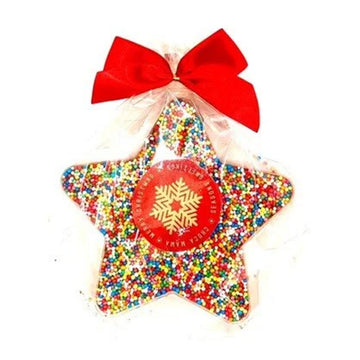 A star shaped chocolate covered with sprinkles and wrapped in plastic with a red bow.