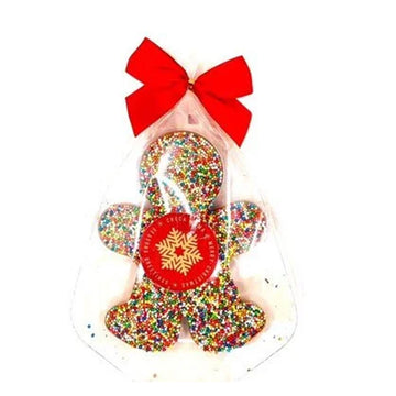 A person shaped chocolate covered with sprinkles and wrapped in plastic with a red bow.
