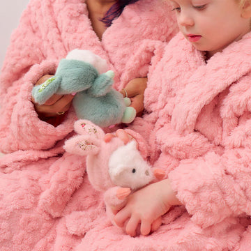 Three soft toys shaped like bears wearing bunny onesies in different colours.