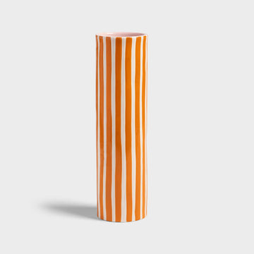 Cylindrical vase with orange and white vertical stripes on a light gray background.